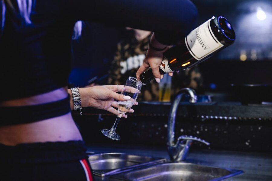 Champagne being poured in a dimly lit bar