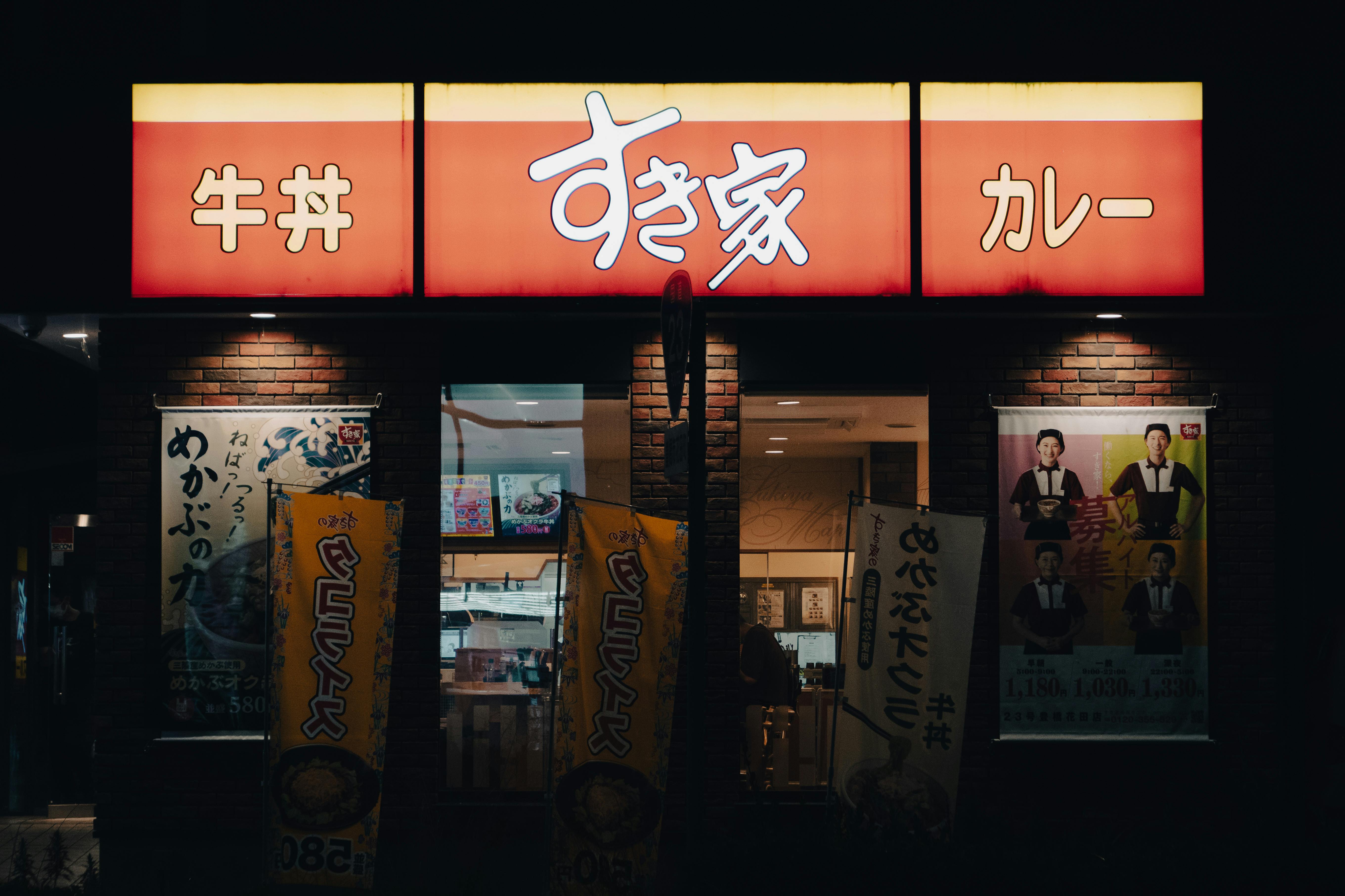 Japanese restaurant at night with distinctive mixed-script signage