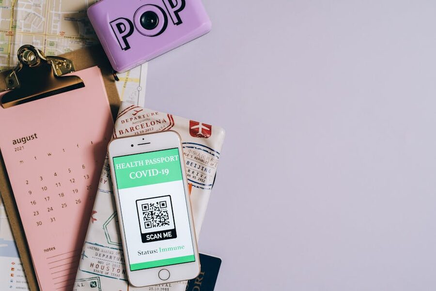 Flat lay of a smartphone displaying a QR-coded health passport with a calendar and travel map