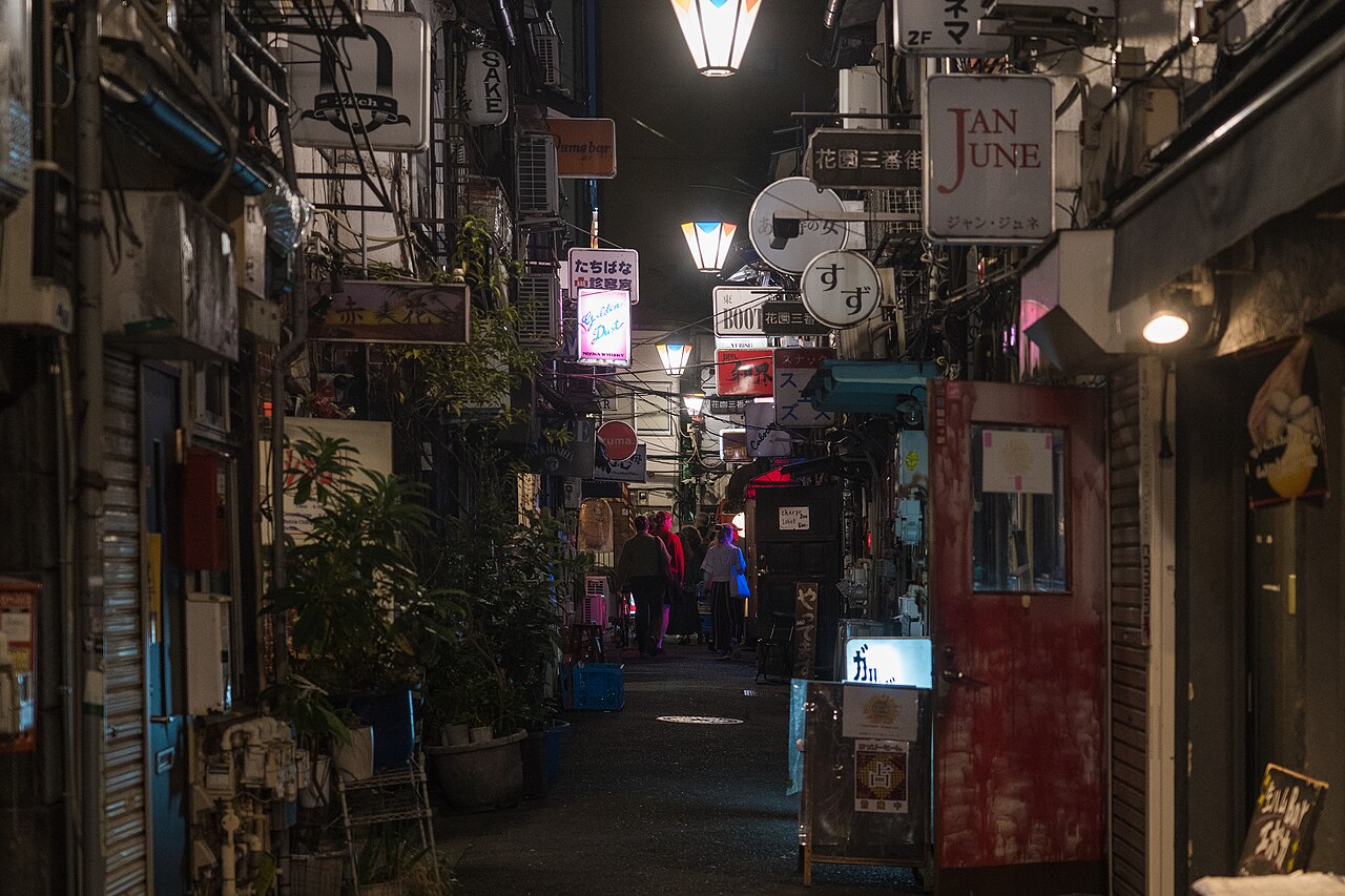 Narrow alley with tiny bars and neon signs in Shinjuku Golden Gai, Tokyo